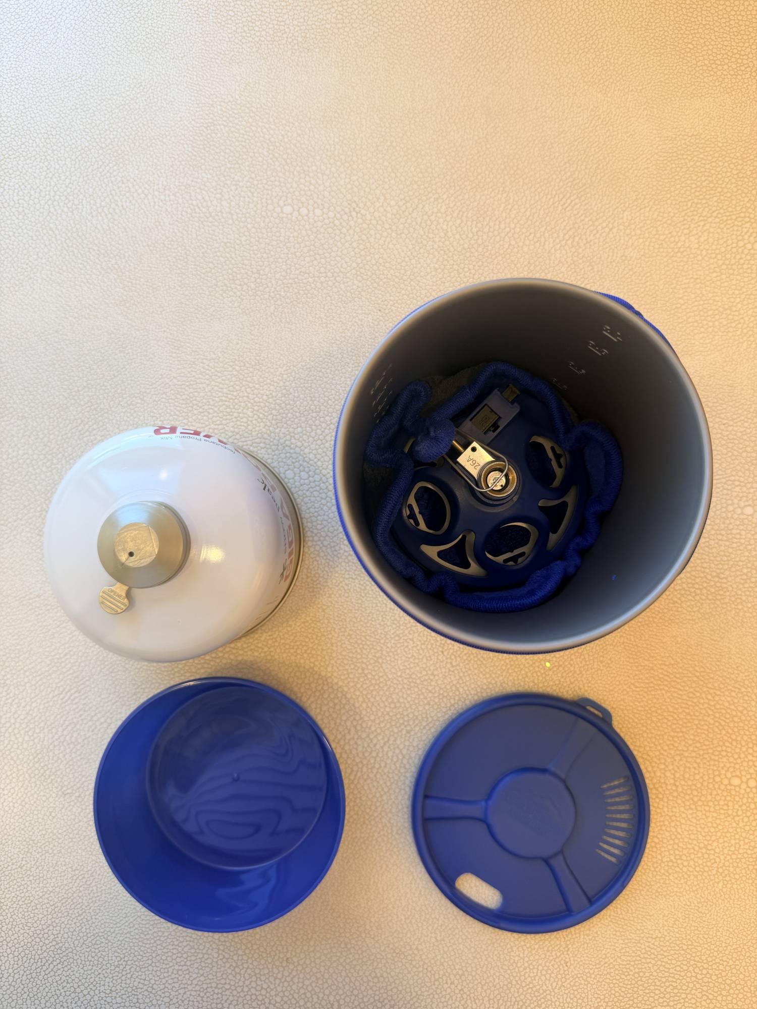 Burner nested inside the Coastal Range Backpacker pot, cushioned by the microfiber cleaning towel.