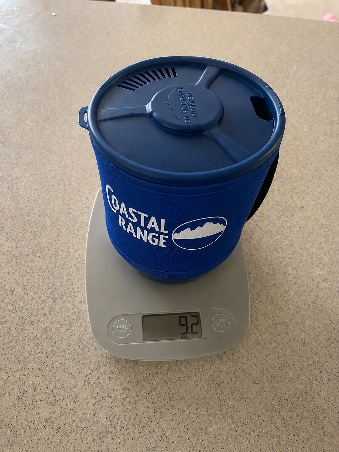 The Backpacker integrated camping stove weighing 9.2 ounces on a digital kitchen scale.