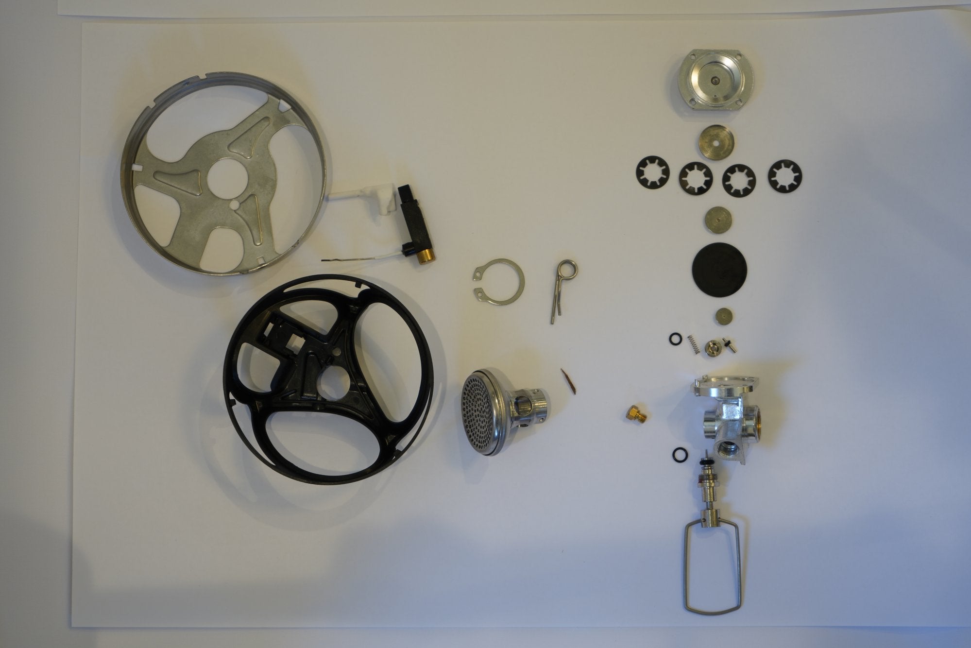 Every part of the Backpacker stove laid out — pot supports, burner cup, valve, igniter, and hardware, each engineered for minimum weight