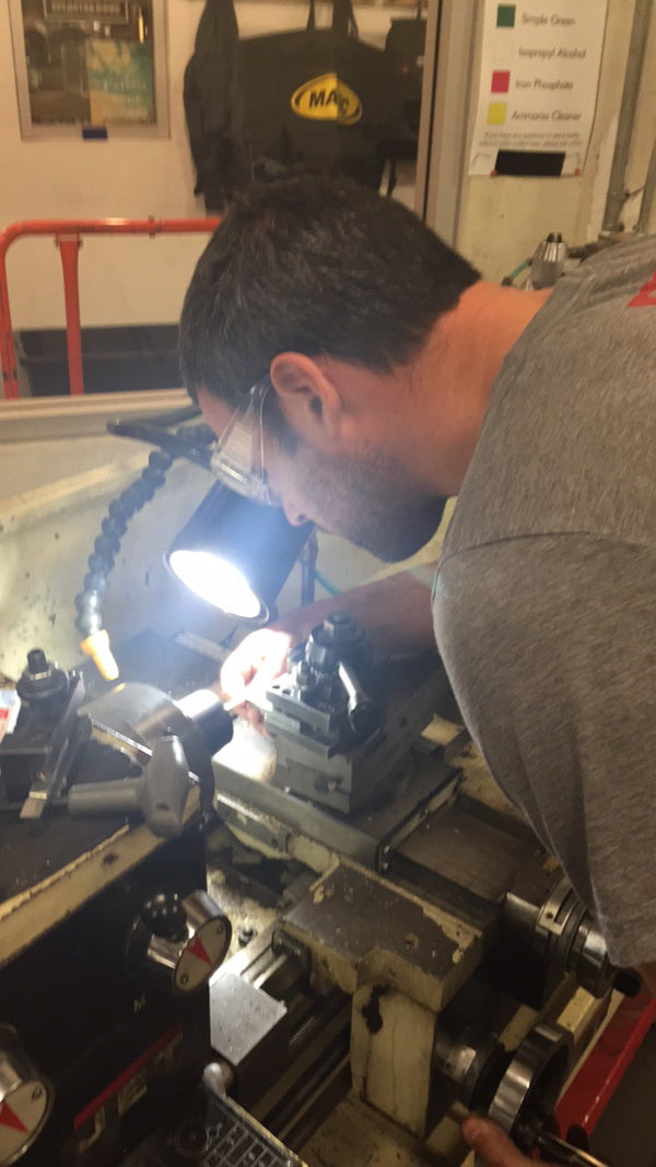 Founder John Peretti machining a stove component on a metal lathe