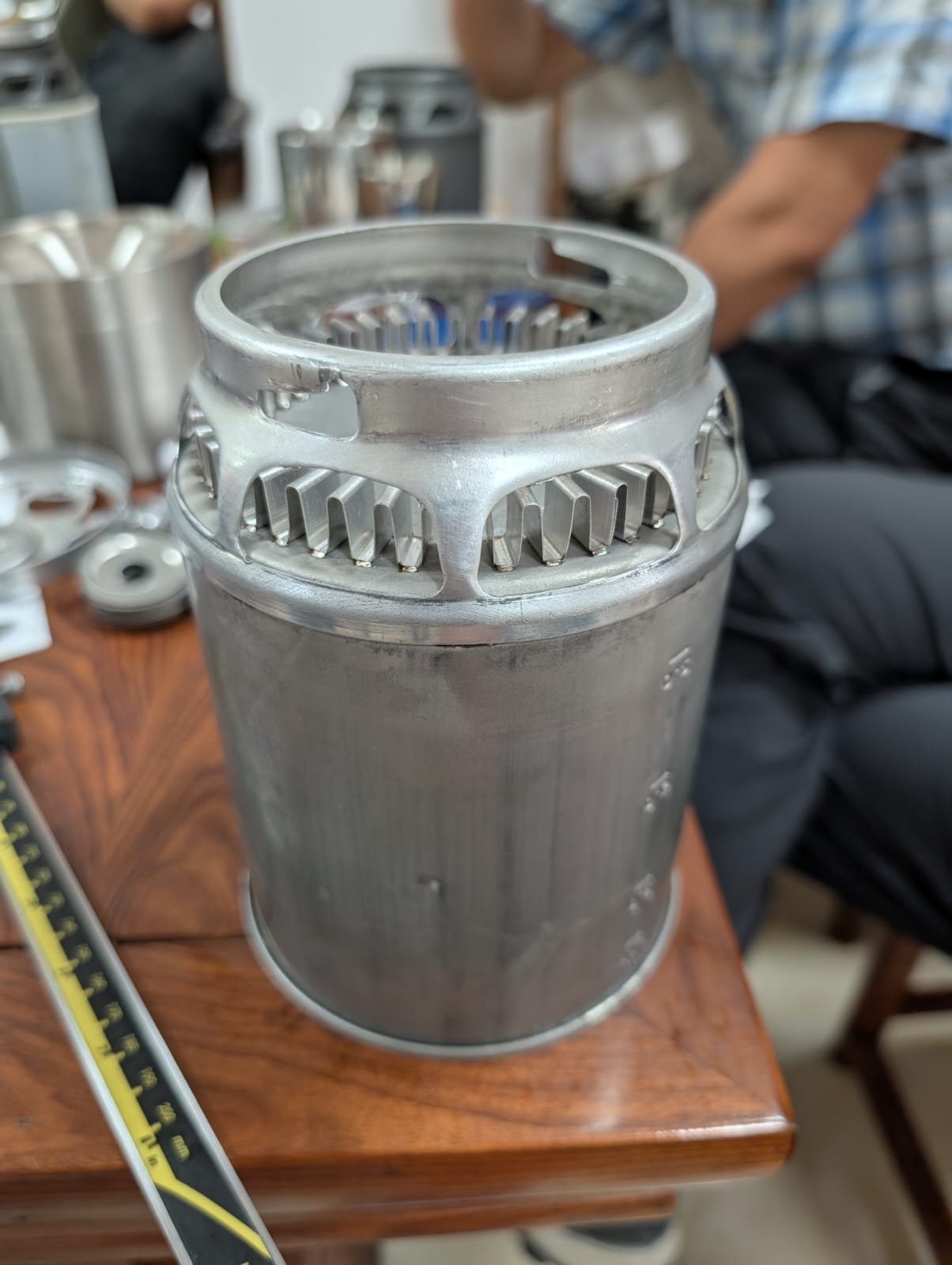 Finned aluminum heat-exchanger prototype measured against a ruler for scale