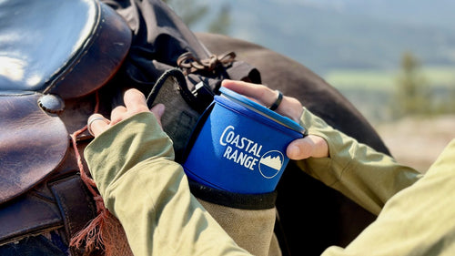 A hand tucking the packed Backpacker system into a leather saddlebag